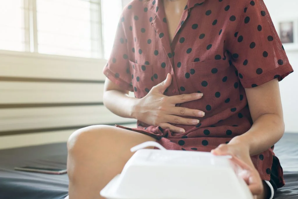 Woman with stomach pain after eating