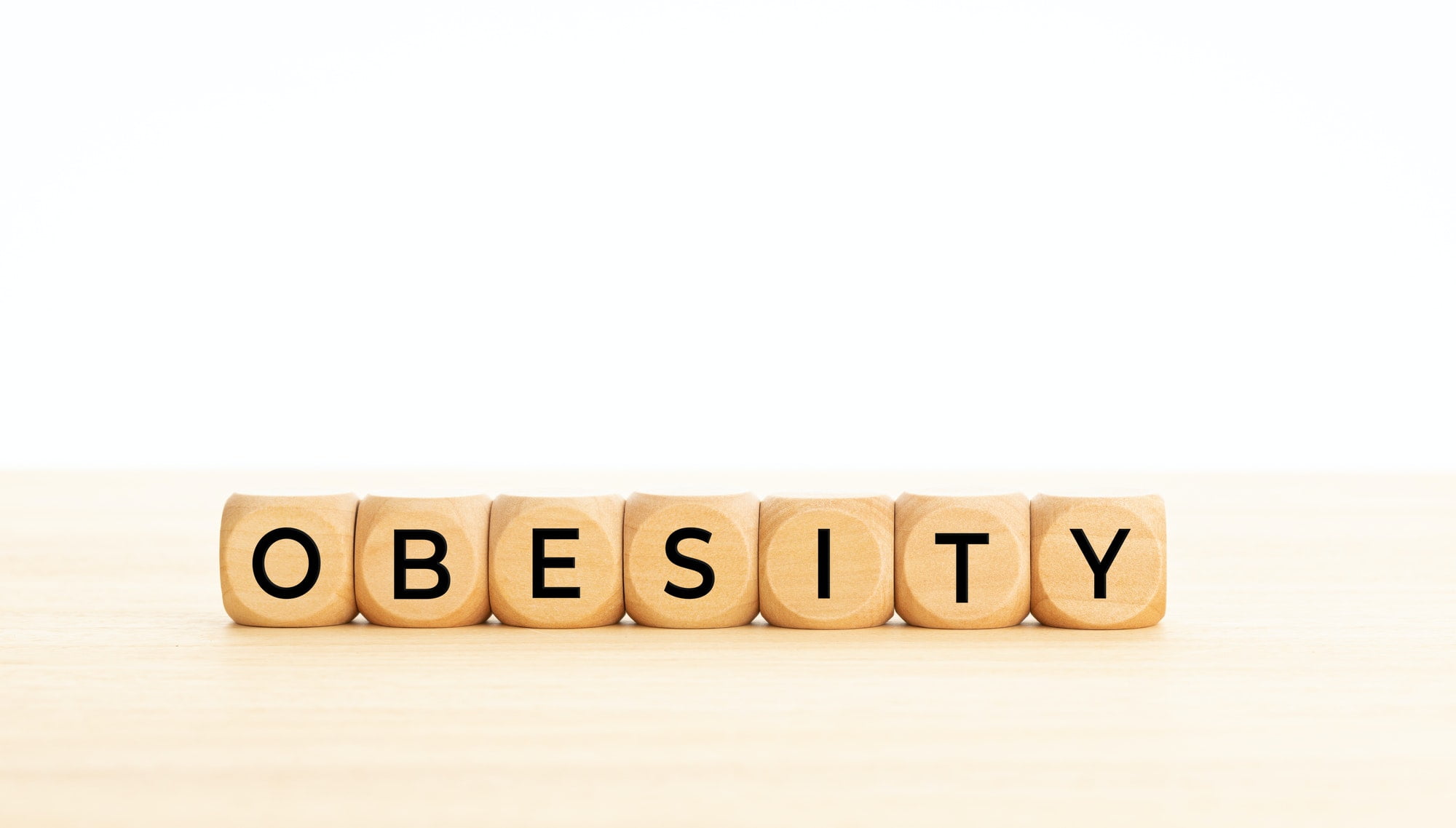 Gojaznost Obesity word on wooden block